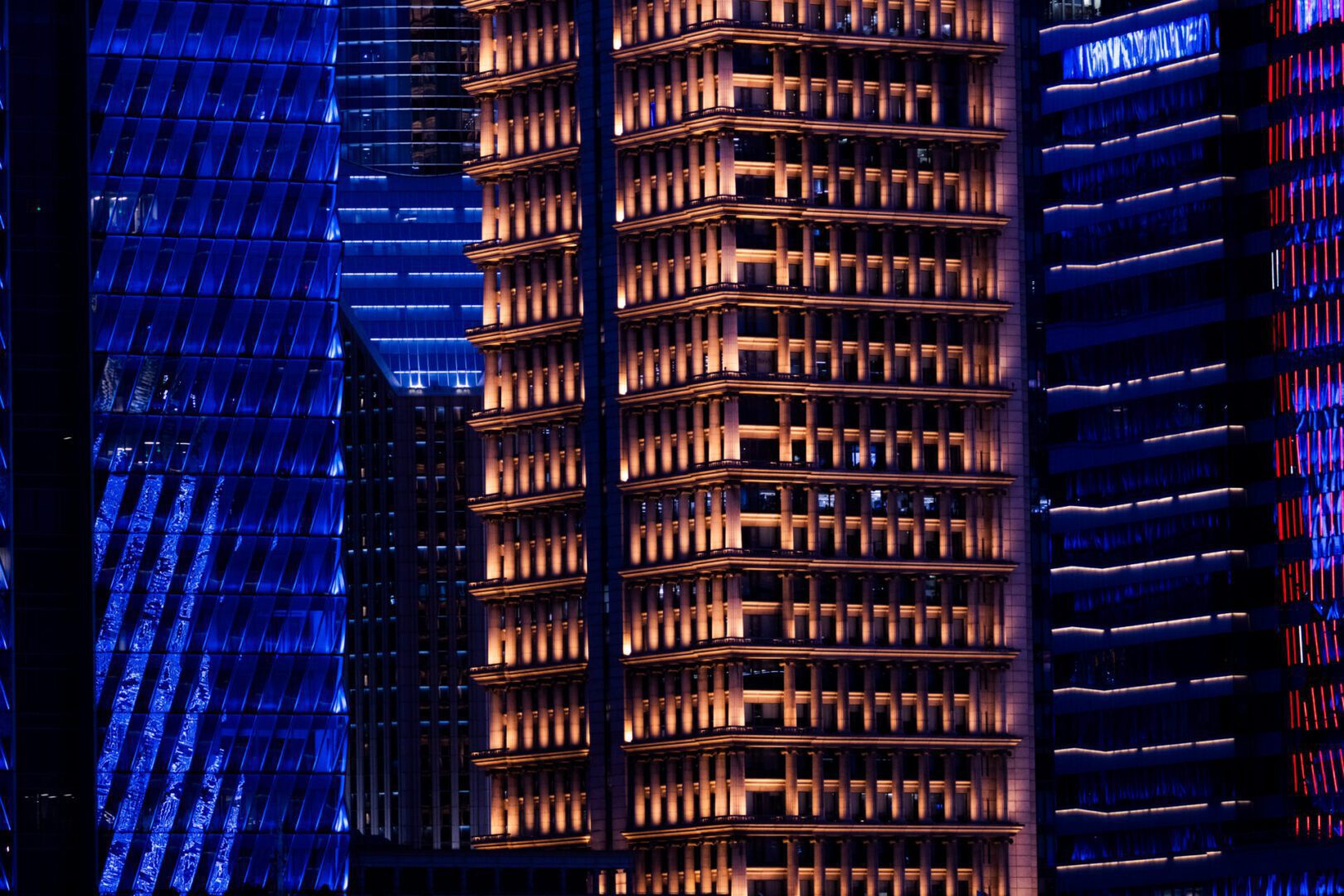 Skyscrapers illuminated with blue and orange lights.